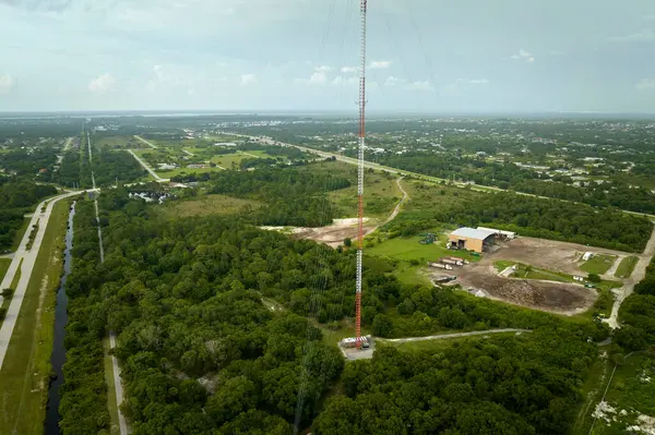 Aerial view of telecommunications cell phone tower with wireless communication 5g antennas for network signal transmission.