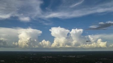 Florida kırsalında hareket eden ve değişen bulutlu hava koşulları. Yazın mavi gökyüzünde fırtınadan önce oluşan beyaz kümülonimbus bulutlarının zaman akışı.