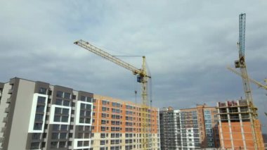 Vinç kaldırma kulesi ve inşaat halindeki monolitik çerçeveli yüksek konutlu bina. Gayrimenkul geliştirme.