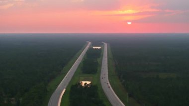 Florida 'daki kalabalık I-75 otobanından gün doğumunda trafiğin hızla ilerlediği manzarayı izleyin. Eyaletler arası hızlı ulaşım kavramı.