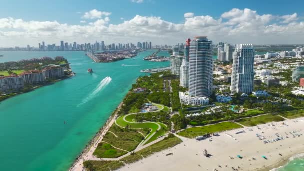 マイアミ港に入る商業コンテナ船はサウスビーチ近くの主要水路を通っている ウォーターフロントの豪華なホテルや住宅 遠くにダウンタウンの高層ビルの塔 — ストック動画