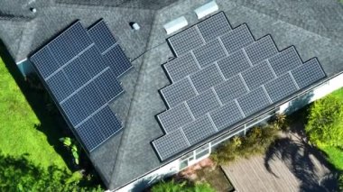 Banliyö bölgesinde temiz ekolojik elektrik enerjisi üretmek için çatısı güneş fotovoltaik panellerle kaplı Amerika 'daki sıradan bir ev. Özerk konut kavramı.
