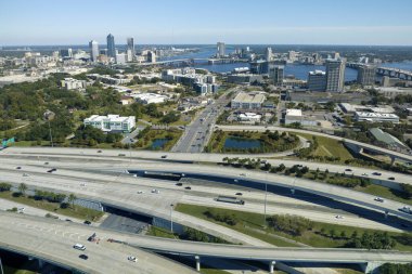 Jacksonville şehrinin hava manzarası. Yüksek ofis binaları ve hızlı araba ve kamyonlarla Amerikan otoyolu kavşağı. ABD ulaşım altyapısının üstünden görüntüle.