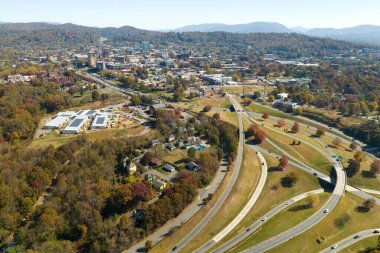 American freeway intersection in Asheville, North Carolina with fast driving cars and trucks in autumnal season. View from above of USA transportation infrastructure.