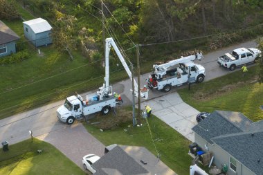 Elektrik işçileri Florida yerleşim bölgesindeki Ian Kasırgası 'ndan sonra kova kamyonları kullanarak hasar gören elektrik hatlarını onarıyor..