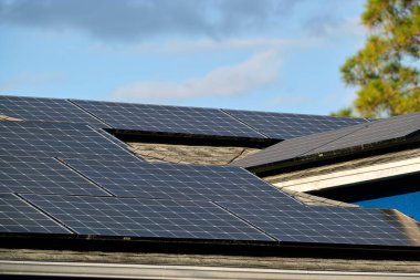 Şehrin kırsal kesimlerinde temiz ekolojik elektrik enerjisi üretmek için güneş fotovoltaik panellerle kaplı özel bir çatı. Özerk ev kavramı.
