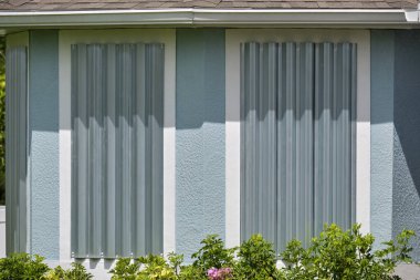 Kasırganın ev pencerelerini koruması için çelik çarşaflar, fırtına kepenkleri olarak monte edildi. Florida 'daki doğal felaketten önce koruyucu tedbirler.