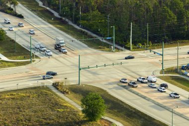 Trafik ışıklarıyla kesişen geniş, çoklu şeritli bir yoldan görüntüyü al. ABD 'de şehir ulaşımı. Amerikan şehir trafiği.