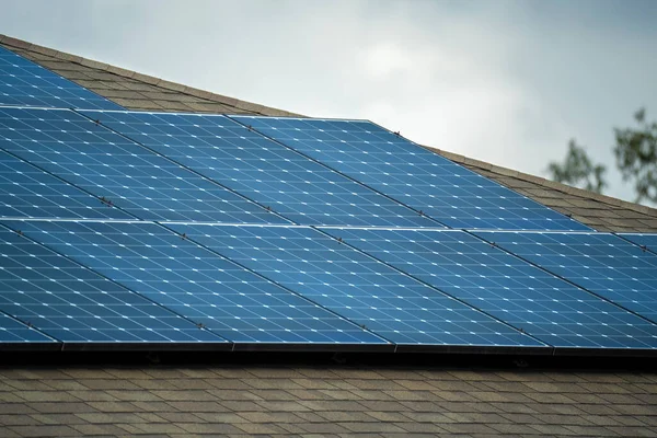 Banliyö bölgesinde temiz ekolojik elektrik enerjisi üretmek için çatısı güneş fotovoltaik panellerle kaplı Amerika 'daki sıradan bir ev. Özerk konut kavramı.