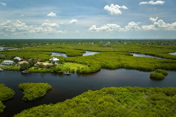 Overhead view of Everglades swamp with green vegetation between water inlets and rural private houses. Natural habitat of many tropical species in Florida wetlands.
