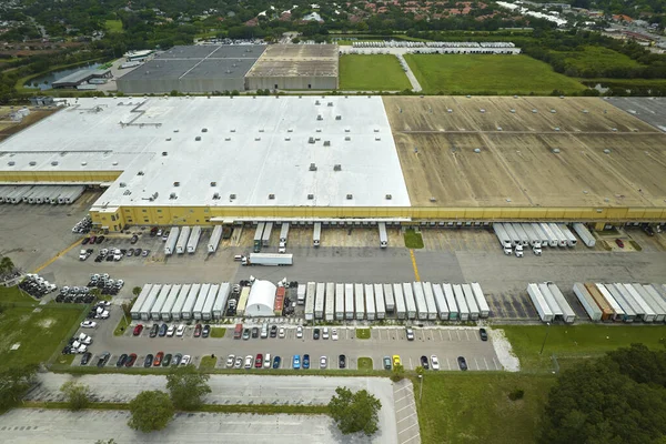 stock image Top view of giant logistics center with many commercial trailer trucks unloading and uploading retail products for further shipment. Global economy concept.