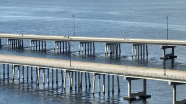 Aerial view of Barron Collier Bridge and Gilchrist Bridge in Florida with moving traffic. Transportation infrastructure in Charlotte County connecting Punta Gorda and Port Charlotte over Peace River.