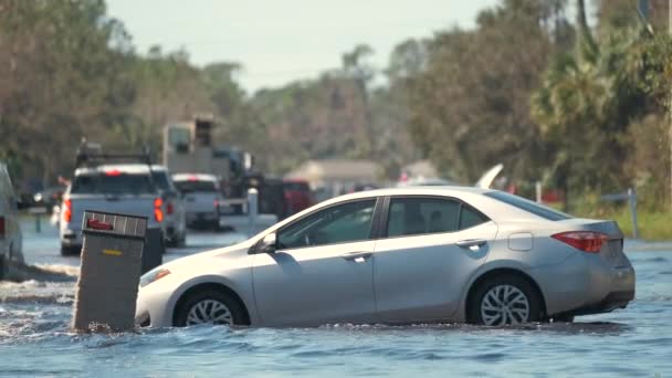 フロリダの住宅地に水で囲まれた移動する車でアメリカの通りが浸水した ハリケーンイアンの自然災害の結果 — ストック動画