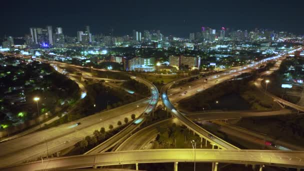 米国の交通インフラの上からの眺め フロリダ州マイアミ市の高速道路の車やトラックと夜のアメリカの高速道路の交差点の空中ビュー — ストック動画
