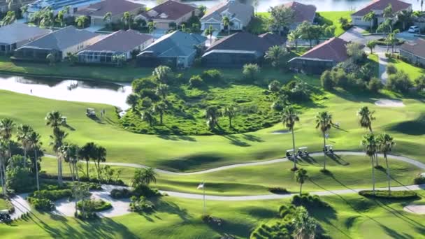富人的积极生活方式 在阳光灿烂的佛罗里达州的广阔的绿色高尔夫球场上 空中观看选手们在打高尔夫球 富人的积极生活方式 — 图库视频影像