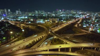 Miami City, Florida 'da gece hızlı giden araba ve kamyonlarla Amerikan otoyolu kavşağının hava görüntüsü. ABD ulaşım altyapısının üstünden görüntüle.