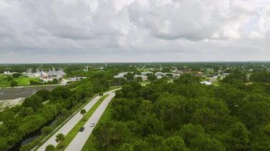 Küçük bir kasabada sokak trafiğinin hava görüntüsü. Florida 'da sakin yerleşim bölgesinde yeşil palmiye ağaçları arasında özel evleri olan Amerikan banliyö manzarası.