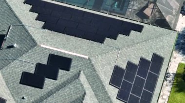 Aerial view of typical american building roof with rows of blue solar photovoltaic panels for producing clean ecological electric energy. Renewable electricity with zero emission concept.