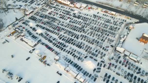 駐車場販売のための多くの車と車のオープン市場のロットの空中ビューや冬に歩く人々 — ストック動画