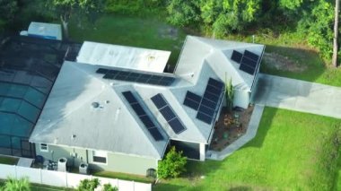 Banliyö bölgesinde temiz ekolojik elektrik enerjisi üretmek için çatısı güneş fotovoltaik panellerle kaplı Amerika 'daki sıradan bir ev. Özerk konut kavramı.