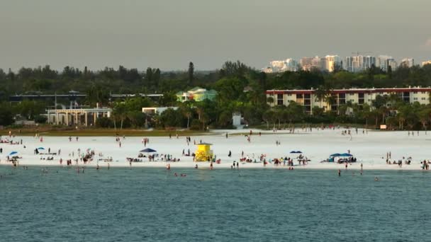 サラソータ 米国の混雑したシエスタキービーチの高角度ビュー 多くの人々は海の水で泳いだり 日没時に暖かいフロリダの太陽の下でリラックスして休暇を楽しんでいます — ストック動画
