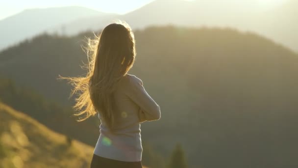 芝生の山頂に一人で立っている孤独な女性ハイカーは 荒野のトレイルで日没の自然の景色を楽しんでいます アクティブライフスタイルコンセプト — ストック動画