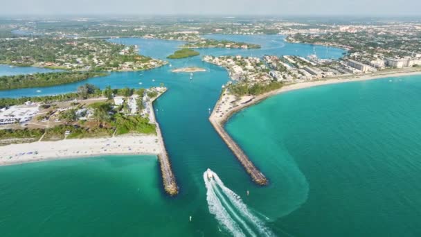 ヴェネツィアの近くの海岸 フロリダ 白いヨットとモーターボートが海の波に乗っています ノカムビーチで北と南のジェティ 海洋表面でのボートレクリエーション — ストック動画