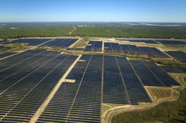 Temiz elektrik enerjisi üretmek için birçok sıra güneş fotovoltaik paneli bulunan sürdürülebilir büyük elektrik santralinin havadan görünüşü. Sıfır emisyon kavramı ile yenilenebilir elektrik.