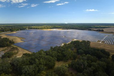 Temiz elektrik enerjisi üretmek için birçok sıra güneş fotovoltaik paneli bulunan sürdürülebilir büyük elektrik santralinin havadan görünüşü. Sıfır emisyon kavramı ile yenilenebilir elektrik.