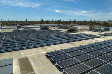 Mavi fotovoltaik güneş panelleri temiz ekolojik elektrik üretmek için endüstriyel binaların çatısına monte edildi. Yenilenebilir enerji konsepti üretimi.