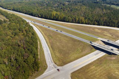 Aerial view of freeway overpass junction with fast moving traffic cars and trucks in american rural area. Interstate transportation infrastructure in USA.