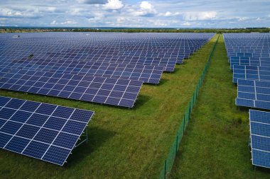 Temiz elektrik enerjisi üretmek için sıra sıra güneş fotovoltaik panelleri olan sürdürülebilir büyük elektrik santralinin havadan görünüşü. Sıfır emisyonlu yenilenebilir elektrik kavramı.