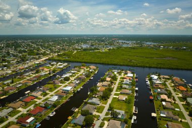 Florida yakınlarındaki deniz kıyısındaki uzak banliyölerdeki kırsal özel evlerin havadan görüntüsü körfez kıyısında yeşil bitki örtüsü olan sulak alanlar. Tropikal bölge kavramında doğaya yakın yaşamak.