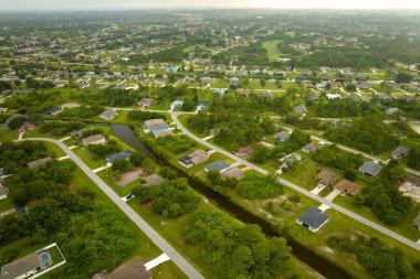 Florida 'nın sakin yerleşim bölgesinde yeşil palmiye ağaçları arasında özel evleri olan küçük bir Amerikan banliyö manzarası..