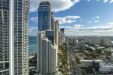 Sunny Isles Sahili 'nin havadan manzarası kalabalık sokak trafiği lüks oteller ve Atlantik Okyanusu kıyısındaki apartmanlar. Güney Florida 'daki Amerikan turizm altyapısı.