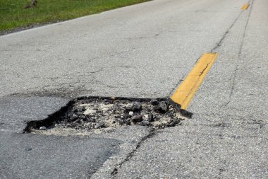 Amerikan yol yüzeyinde tehlikeli bir çukur. Tamire ihtiyacı olan harap bir garaj yolu..