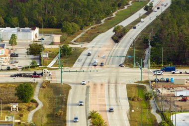 Trafik ışıklarıyla kesişen geniş yol manzaralı. ABD 'de şehir ulaşımı. Amerikan şehir trafiği yukarıdan.