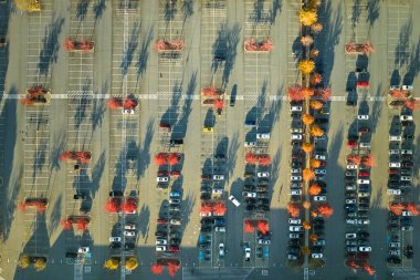 Otoparktaki park yeri ve park yerleri için çizgiler ve işaretler olan birçok aracın görüntüsü. Bir alışveriş merkezinin önünde araçlar için yer.