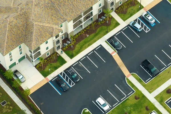 Cars parked on parking place of new apartment condos in Florida suburban area. Family housing in quiet neighborhood. Real estate development in american suburbs.