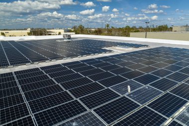 Mavi fotovoltaik güneş panelleri temiz ekolojik elektrik üretmek için endüstriyel binaların çatısına monte edildi. Yenilenebilir enerji konsepti üretimi.