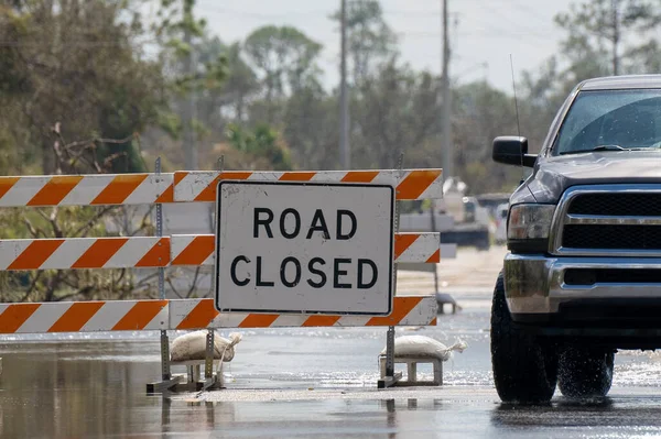 stock image Flooded street in Florida after hurricane rainfall with road closed signs blocking driving of cars. Safety of transportation during natural disaster concept.