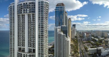 Sunny Isles Beach City 'deki Atlantik Okyanusu kıyısındaki lüks otellerin ve apartmanların manzarası. Güney Florida 'daki Amerikan turizm altyapısı.