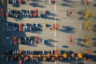 Otoparktaki park yeri ve park yerleri için çizgiler ve işaretler olan birçok aracın görüntüsü. Bir alışveriş merkezinin önünde araçlar için yer.