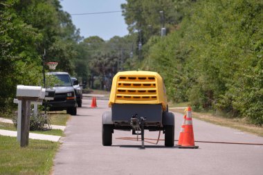 Yol inşaatında kompresör römorklu sarı matkap makinesi..