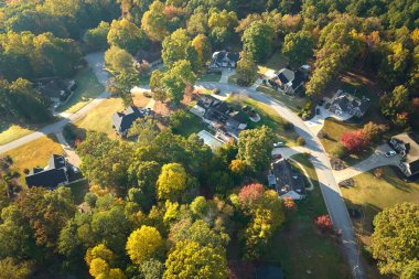 Sonbahar mevsiminde Güney Carolina banliyölerindeki sarı ağaçlar arasındaki yeni aile evlerinin havadan görünüşü. Amerikan banliyölerinde gayrimenkul geliştirme.