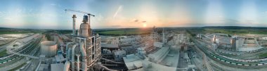 Yüksek fabrika yapısı olan çimento fabrikası ve endüstriyel üretim bölgesinde kule vinçleri var. Üretim ve küresel sanayi kavramı.