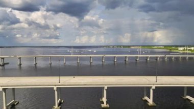 Aerial view of Barron Collier Bridge and Gilchrist Bridge in Florida with moving traffic. Transportation infrastructure in Charlotte County connecting Punta Gorda and Port Charlotte over Peace River.