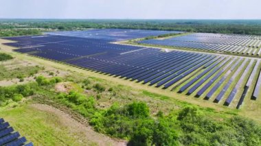 Temiz elektrik enerjisi üretmek için birçok sıra güneş fotovoltaik paneli bulunan sürdürülebilir büyük elektrik santralinin havadan görünüşü. Sıfır emisyon kavramı ile yenilenebilir elektrik.