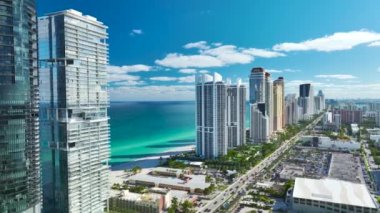 Sunny Isles Sahili 'nin havadan manzarası kalabalık sokak trafiği lüks oteller ve Atlantik Okyanusu kıyısındaki apartmanlar. Güney Florida 'daki Amerikan turizm altyapısı.