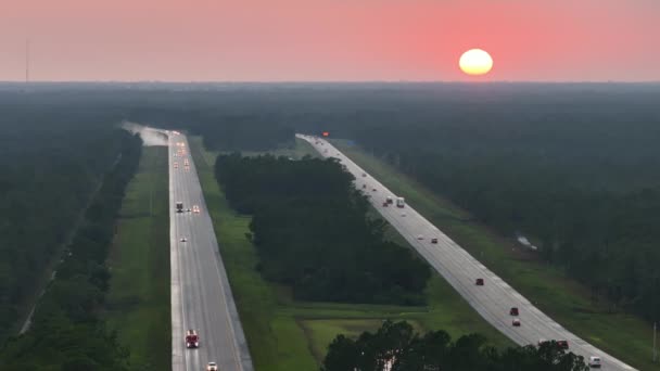 日没時に多くの運転車やトラックと広い混雑したアメリカの高速道路の高い角度ビュー 国際輸送システムの概念 — ストック動画